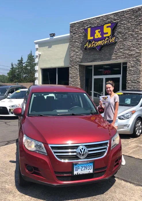 L & S Automotive happy customer standing in front of our dealership picture